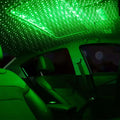 Interior view of a car lit with green star decoration lights creating a unique and romantic atmosphere.